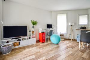 a living room with a flat screen tv and a wooden floor at Charming 1br with terrace close to Paris - Asnières - Welkeys in Asnières-sur-Seine