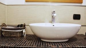 a bathroom with a white bowl sink and a basket at La tua Kimera in Rozzano