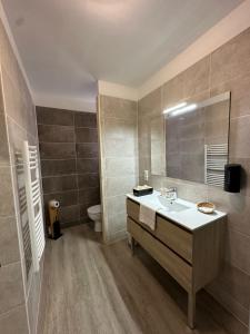 a bathroom with a sink and a toilet at Logis Hôtels - Hôtel et Restaurant Le Lion d'Or in Gramat