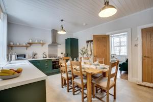 uma cozinha e sala de jantar com uma mesa de madeira e cadeiras em Sage Cottage: Homely, Cosy Cottage with Log Burner em Buxton