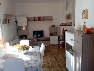 a kitchen with a table with a bowl of fruit on it at Casa vacanze Il Carrubo in Leporano