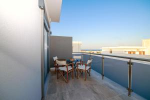 - un balcon avec deux chaises et une table dans l'établissement Calma Apartment, à Rhodes