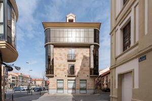 um edifício de tijolos alto com uma torre de relógio no topo em Apartamentos Suite The Way em Astorga