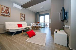 - un salon avec un canapé blanc et des oreillers rouges dans l'établissement Calma Apartment, à Rhodes