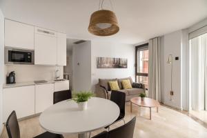 cocina y sala de estar con mesa blanca y sillas en Apartamentos Suite The Way, en Astorga