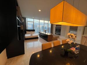 a kitchen and living room with a table and a couch at Platinum Suites KLCC by MoonOrchid in Kuala Lumpur