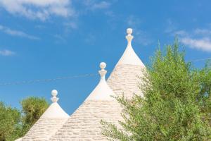 a tip of a building with a blue sky in the background at Trullo Zese con Piscina Privata in San Michele Salentino