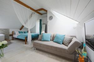 een woonkamer met een bank en een bed bij Lotti Residence Romantik in Balatonfüred