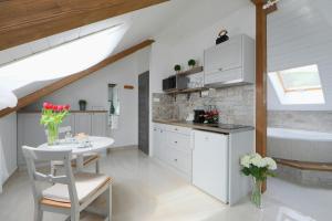 a white kitchen with a table and a bath tub at Lotti Residence Romantik in Balatonfüred