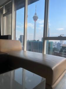 a bed in a room with a view of a city at Platinum Suites KLCC by MoonOrchid in Kuala Lumpur