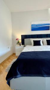 a bedroom with a large bed with a blue blanket at Apartments Corina in Zagreb