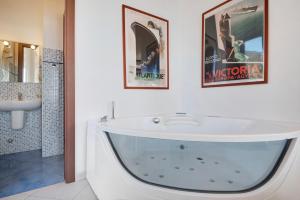 a white bathroom with a tub and a sink at Serra Monolocale in Bonassola
