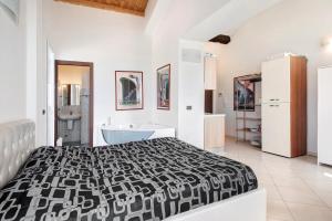 a bedroom with a black and white bed and a bathroom at Serra Monolocale in Bonassola