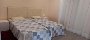 - une chambre avec un lit et une couverture en damier dans l'établissement Rocha Apartment Plus, à Portimão