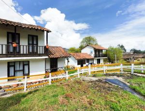 a group of houses with a white fence at La Posada Campestre Cabañas in El Cocuy