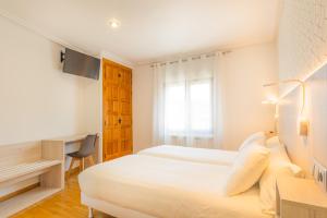 Łóżko lub łóżka w pokoju w obiekcie Hostal Gran Duque