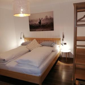 a bed in a bedroom with a picture on the wall at Apartment mit Terrasse und Garten in Saalfelden am Steinernen Meer