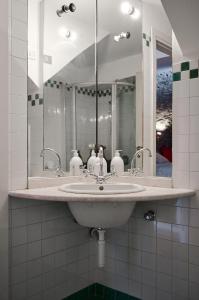 bagno con lavandino e grande specchio di CasaBlanca charme & relax a Bergamo