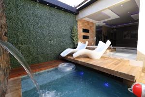 una piscina con 2 sillas blancas y una piscina en A2 Motel, en Ribeirão Preto