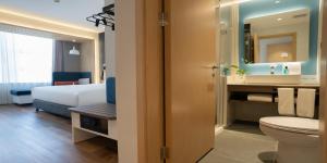 乌鲁木齐Holiday Inn Express Urumqi Station by IHG的带床、马桶和水槽的浴室