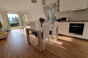 Una cocina y un comedor con mesa y sillas. en OLIVA NOVA, playa, jardín, piscina, golf, MET, IDEAL FAMILIAS, en Oliva