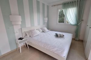 Un dormitorio blanco con una cama y una ventana. en OLIVA NOVA, playa, jardín, piscina, golf, MET, IDEAL FAMILIAS, en Oliva 18 fotos más