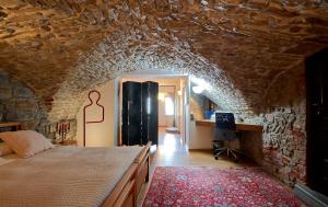 una camera con letto e parete in pietra di CasaBlanca charme & relax a Bergamo