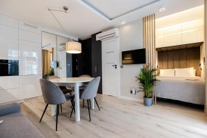 a room with a table and chairs and a bed at Apartment Wola, WI-FI, Smart Lock, Air Condition in Warsaw