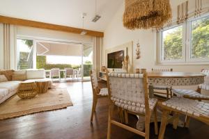 - un salon avec une table et des chaises dans l'établissement Villa Madrugada, beachside villa in Costabella, à Marbella