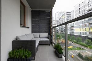 a balcony with a couch and plants on a building at Apartment Wola, WI-FI, Smart Lock, Air Condition in Warsaw