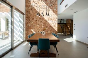 a dining room with a wooden table and blue chairs at Es Maiols Casa A in Can Furnet