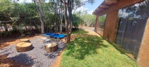 un patio trasero con una mesa de picnic y dos troncos en Hartbees Eco Bush Lodge 1, en Hartbeespoort
