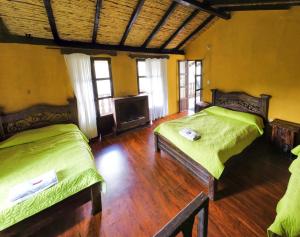 a room with two beds and a tv in it at La Posada Campestre Cabañas in El Cocuy