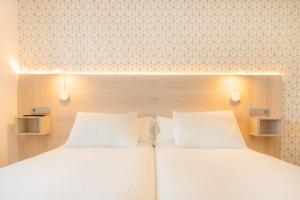 Łóżko lub łóżka w pokoju w obiekcie Hostal Gran Duque