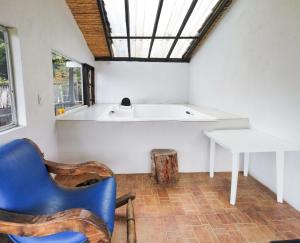 a room with a sink and a blue chair and a table at La Posada Campestre Cabañas in El Cocuy