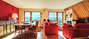 a living room with a table and red chairs at Hostdomus - Rooftop Deluxe Suite in Sestriere