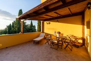 a patio with a table and chairs on a yellow wall at Terrazza sul Tramonto del Silenzio in Laiatico