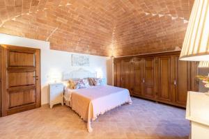 a bedroom with a bed and a brick wall at Terrazza sul Tramonto del Silenzio in Laiatico