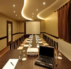 a conference room with a laptop on a long table at Garni Hotel Vozarev in Belgrade