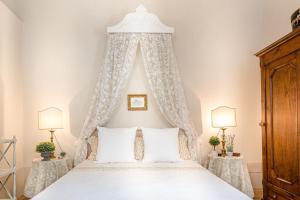 a bedroom with a white bed with a canopy at Casa Janca, Find sanctuary at extraordinary rates! Luxury Smart Apartment in Central Lucca in Lucca