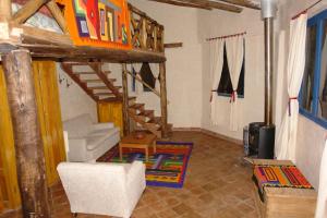 a living room with a loft bed and a staircase at Melissa Wasi in Pisac