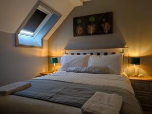 um quarto com uma cama com 2 candeeiros e uma janela em Kingdom Lodge em Killarney