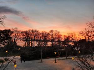 una puesta de sol en un parque con árboles y luces en Casa Mongolfiere Venezia en Venecia