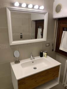 ein Badezimmer mit einem weißen Waschbecken und einem Spiegel in der Unterkunft ANDREA in Mailand