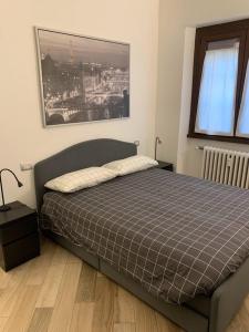 1 dormitorio con 1 cama y una foto en la pared en ANDREA, en Milán