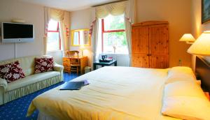 
a bedroom with a bed and a television at Ilkley Riverside Hotel in Ilkley
