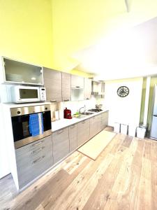 a large kitchen with stainless steel appliances and wooden floors at Attico Darsena Nuova in Ravenna