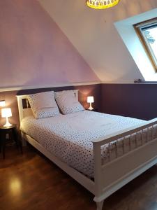 a bedroom with a white bed with two lamps at Magnifique villa avec piscine intérieure in Saint-Pois
