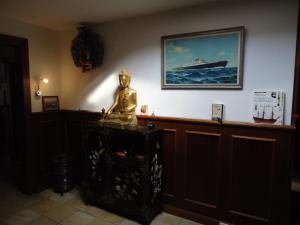 a room with a statue and a picture of a ship at Claes Compaen in Midsland