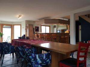 ein Esszimmer mit einem langen Tisch und Stühlen in der Unterkunft Magnifique villa avec piscine intérieure in Saint-Pois